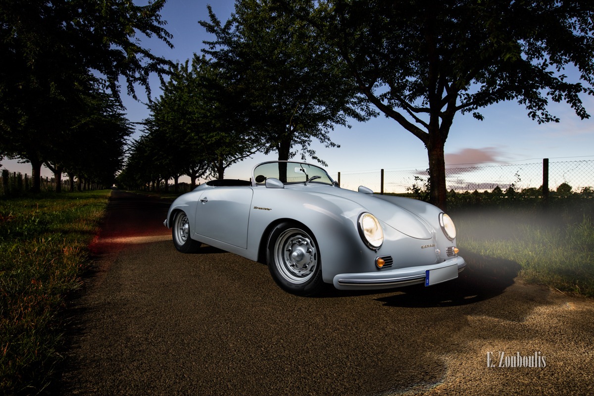 Ein grauer Porsche 356 Speedster am Abend in Stuttgart-Möhringen. Im Hintergrund sind Bäume und Felder und die untergehende Sonne