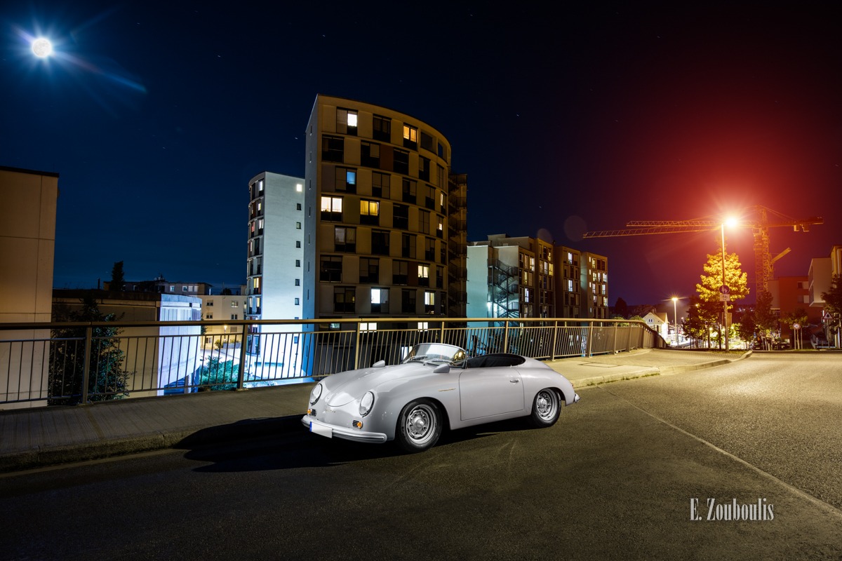 Grauer Porsche 356 Speedster in Stuttgart Möhringen. Seitliche Frontansicht. Links im Hintergrund der Vollmond, der auf die Hochhäuser leuchtet