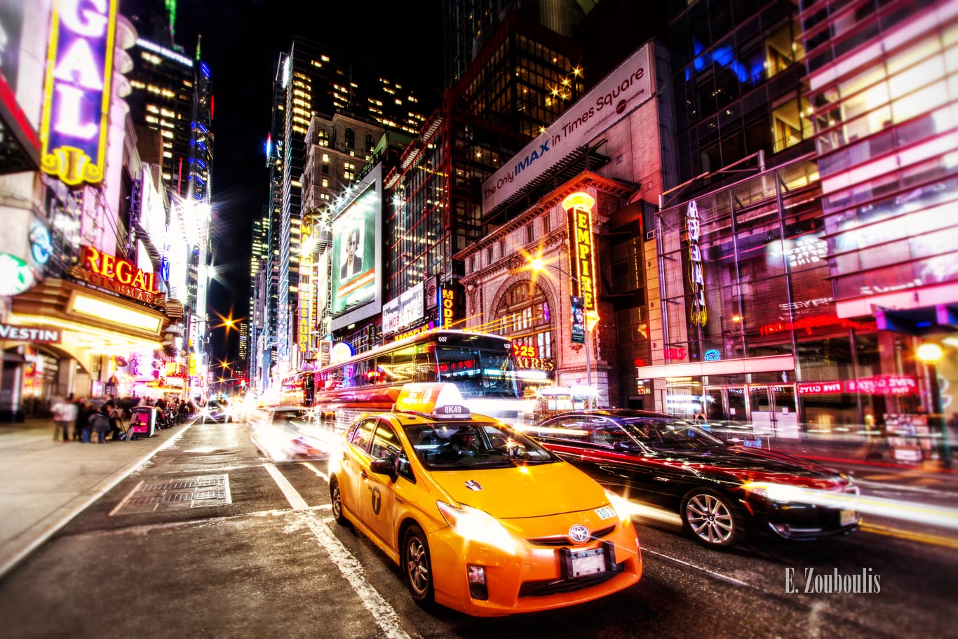 Fahrzeuge, die mitten am Broadway in New York City direkt vor die Kamera fahren, umgeben von funkelnden Lichtern