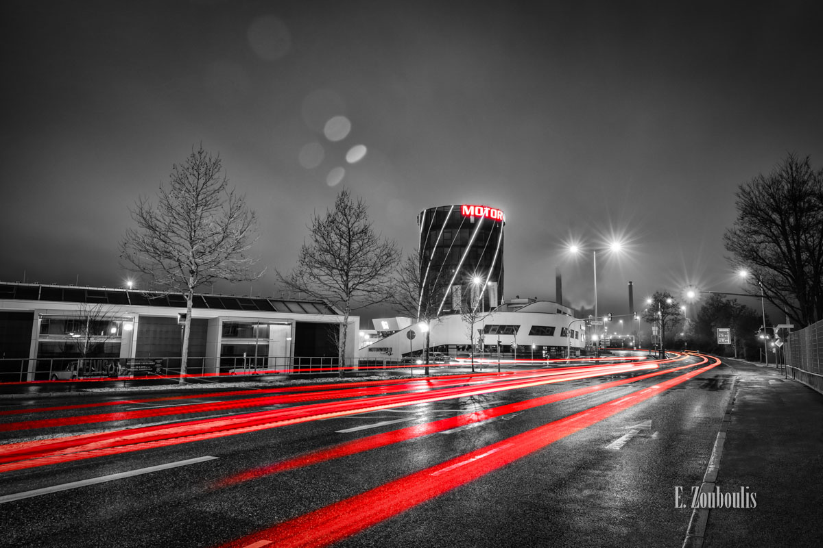 Motorworld Böblingen mit vorbeiziehendem Verkehr bei Nacht